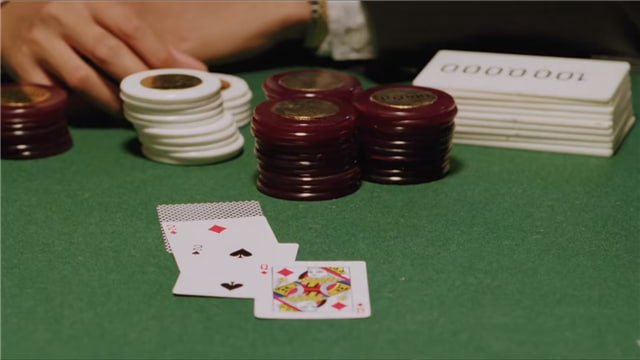 梭哈遊戲桌上的緊張時刻，玩家正準備進行最後一輪全押，桌面上堆滿籌碼，氣氛凝重。
